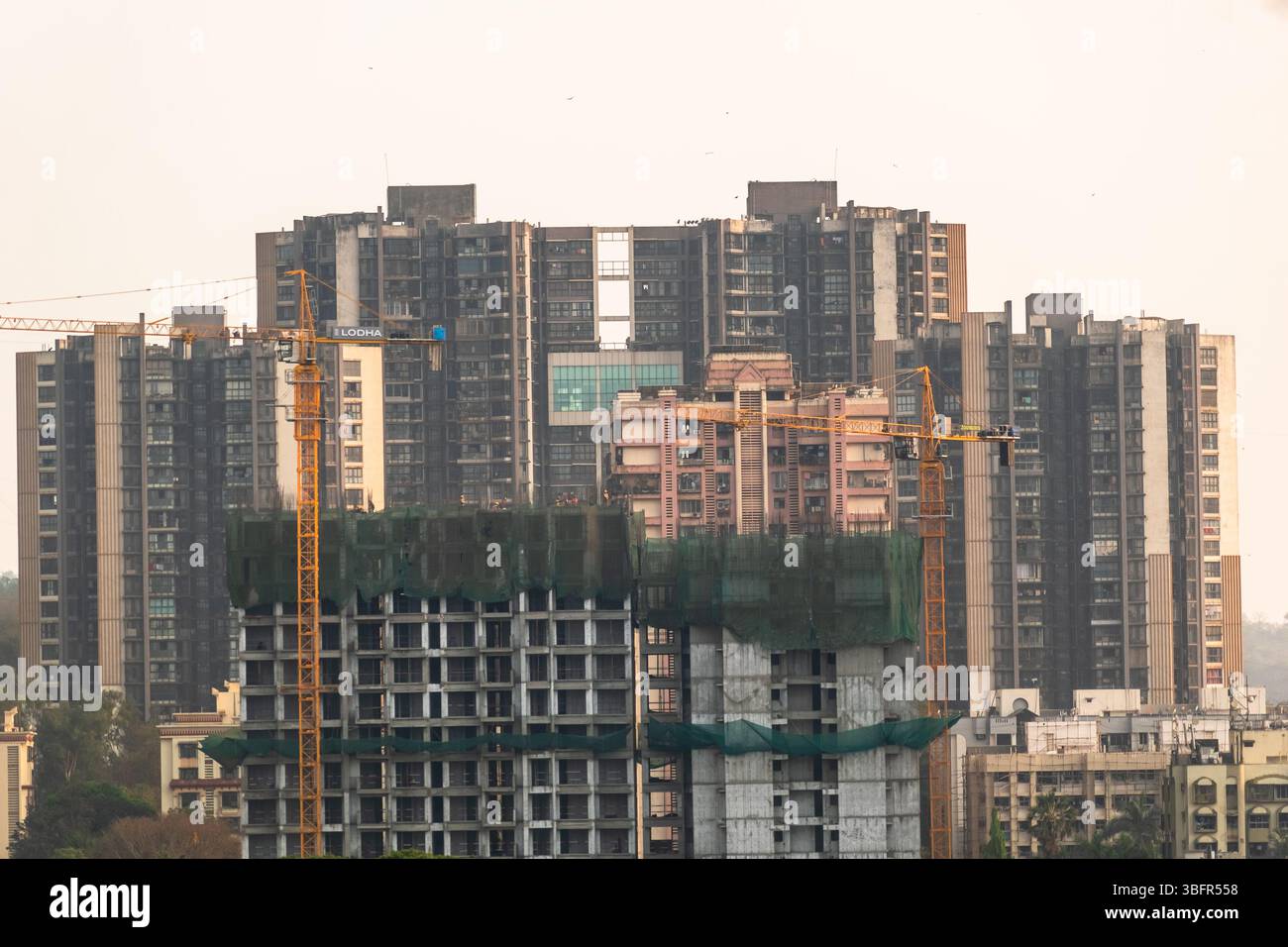 High-rise buildings are under construction in Mumbai, with cranes actively working on site. Stock Photo