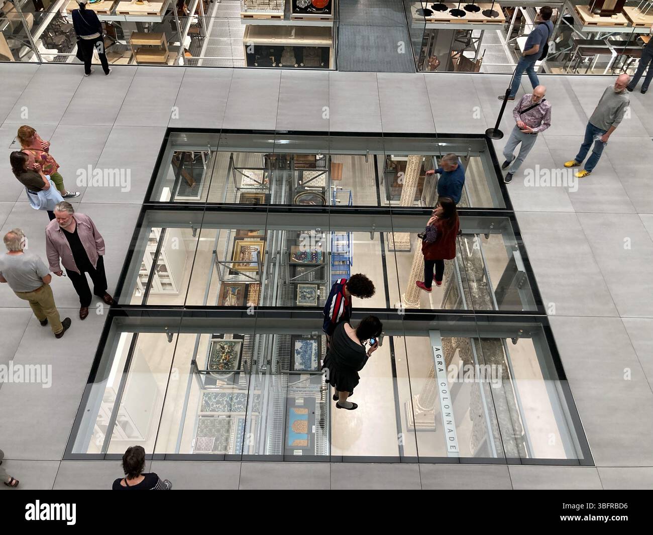 A section of glass floor allows visitors to see behind the scenes at the V&A East Storehouse, Queen Elizabeth Olympic Park, London, UK - Smartphone Captured Stock Image