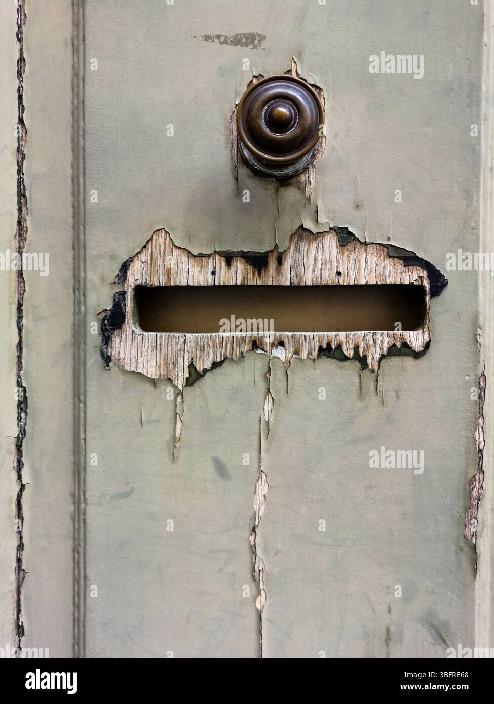 A weathered door in an urban setting features peeling paint and a rusty mail slot. The worn appearance reflects the passage of time - Smartphone Captured Stock Image