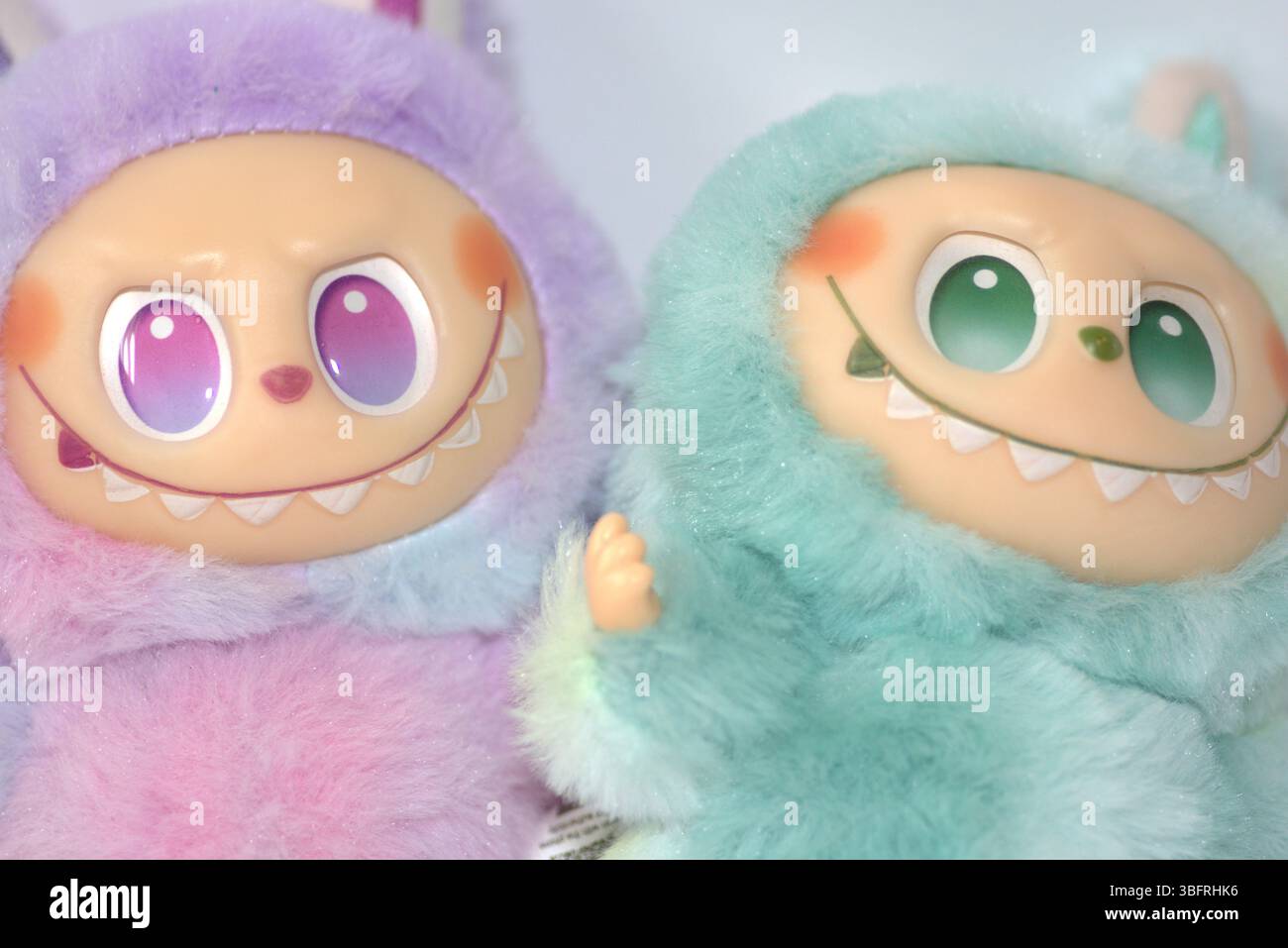 Two playful Labubu toy figures in a fluffy green and pink monster ...