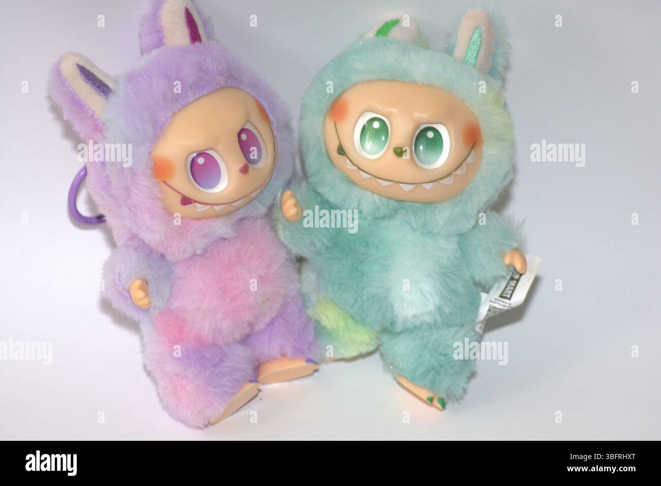 Two playful Labubu toy figures in a fluffy green and pink monster ...