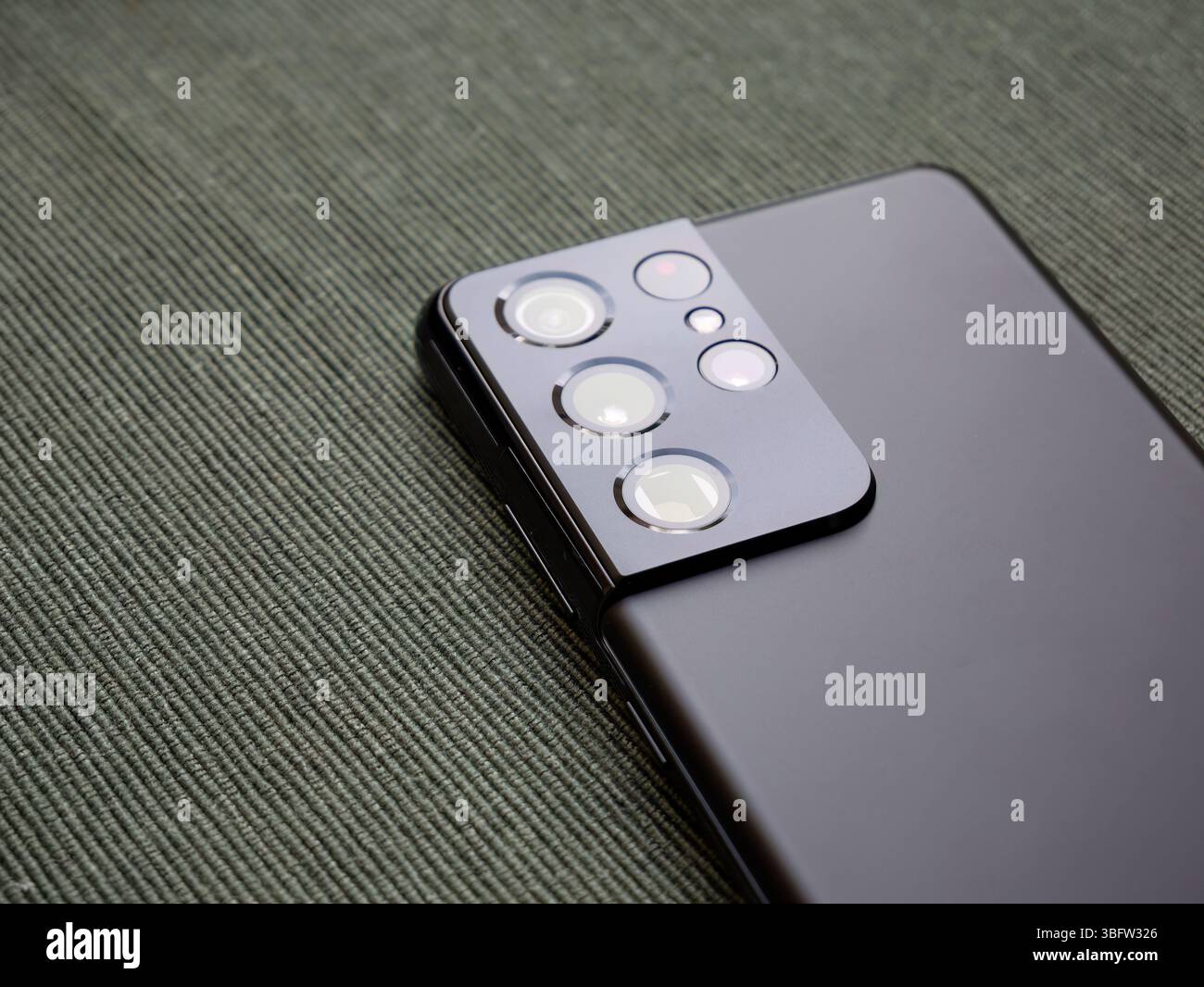 Closeup of a SGS 21 Samsung Galaxy S21 Ultra smartphone back part with multiple camera lenses macro view of a mobile phone quad camera module and matt Stock Photo