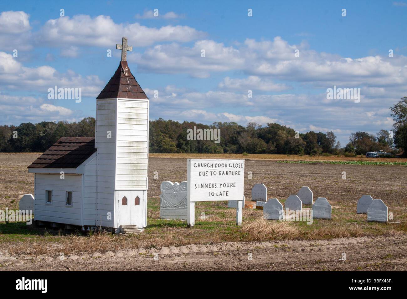 Church Dood Close Due To Rarture in Oak City, North Carolina. Miniature church (maybe eight feet tall at the tip of the cross) and tombstones. Stock Photo