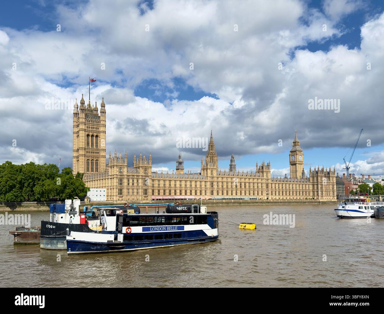LONDON, ENGLAND – MAY 25, 2025: The Palace of Westminster stands beside the River Thames under a partly cloudy sky. - Smartphone Captured Stock Image