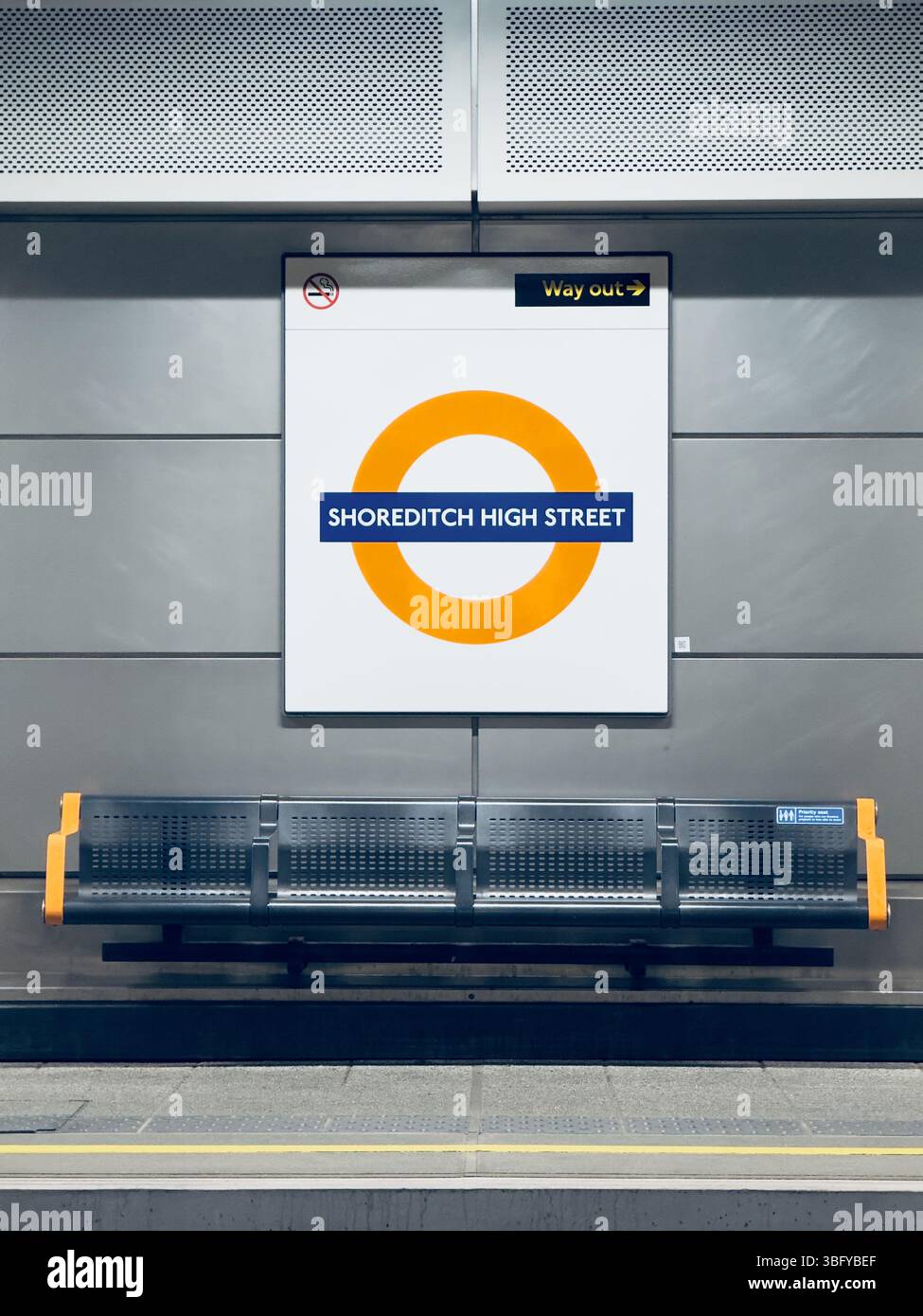 LONDON, ENGLAND – APRIL 6, 2025: The platform at Shoreditch High Street tube station in London is shown, featuring the iconic roundel sign and seating - Smartphone Captured Stock Image