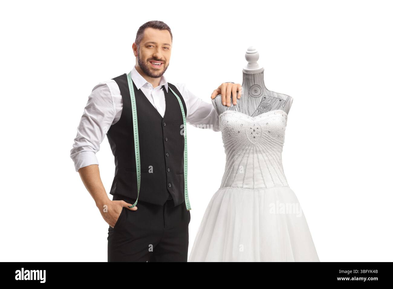 Tailor standing next to a bridal gown isolated on white background Stock Photo