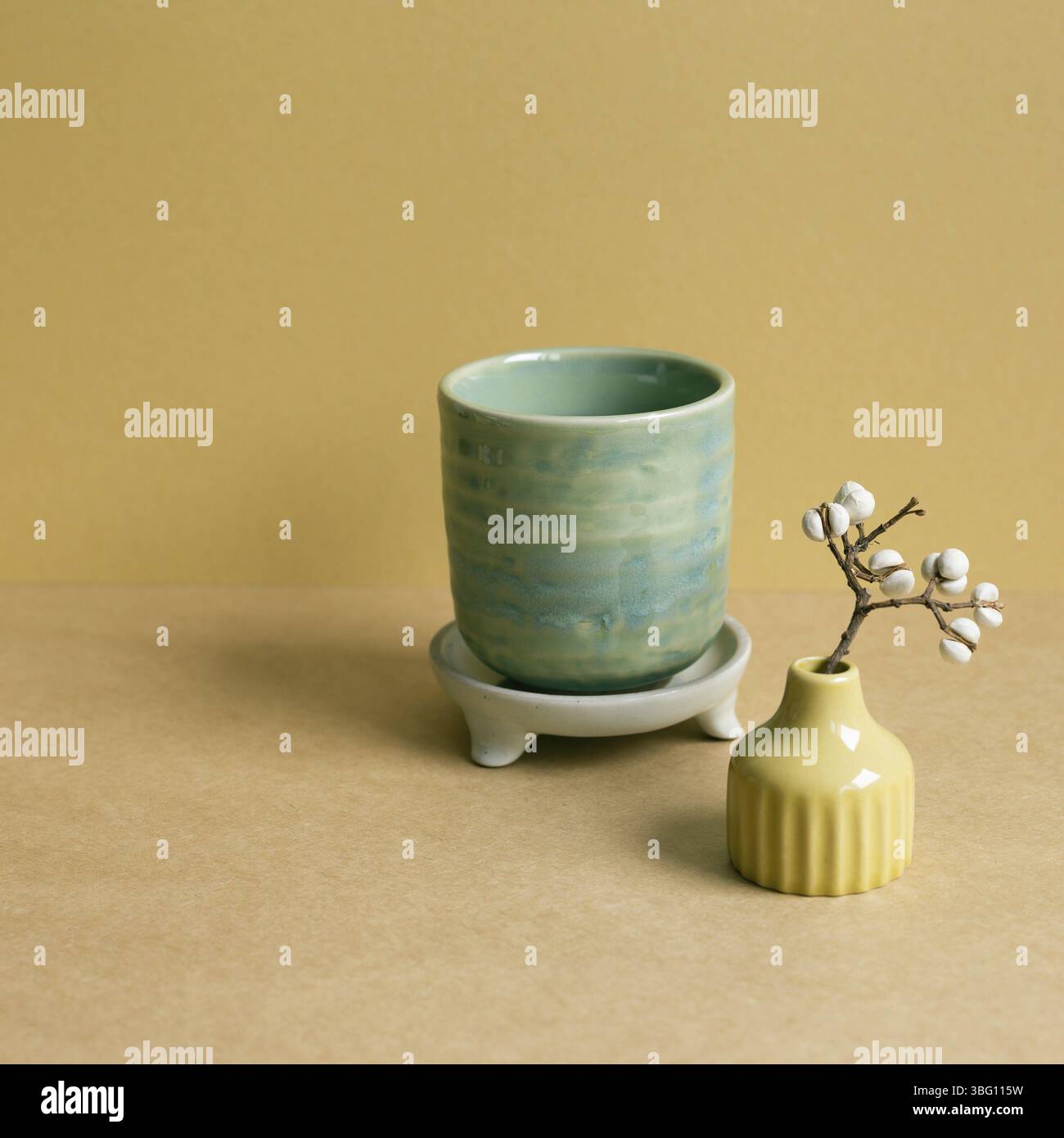 Ceramic tea cup with dry plant on brown table background Stock Photo