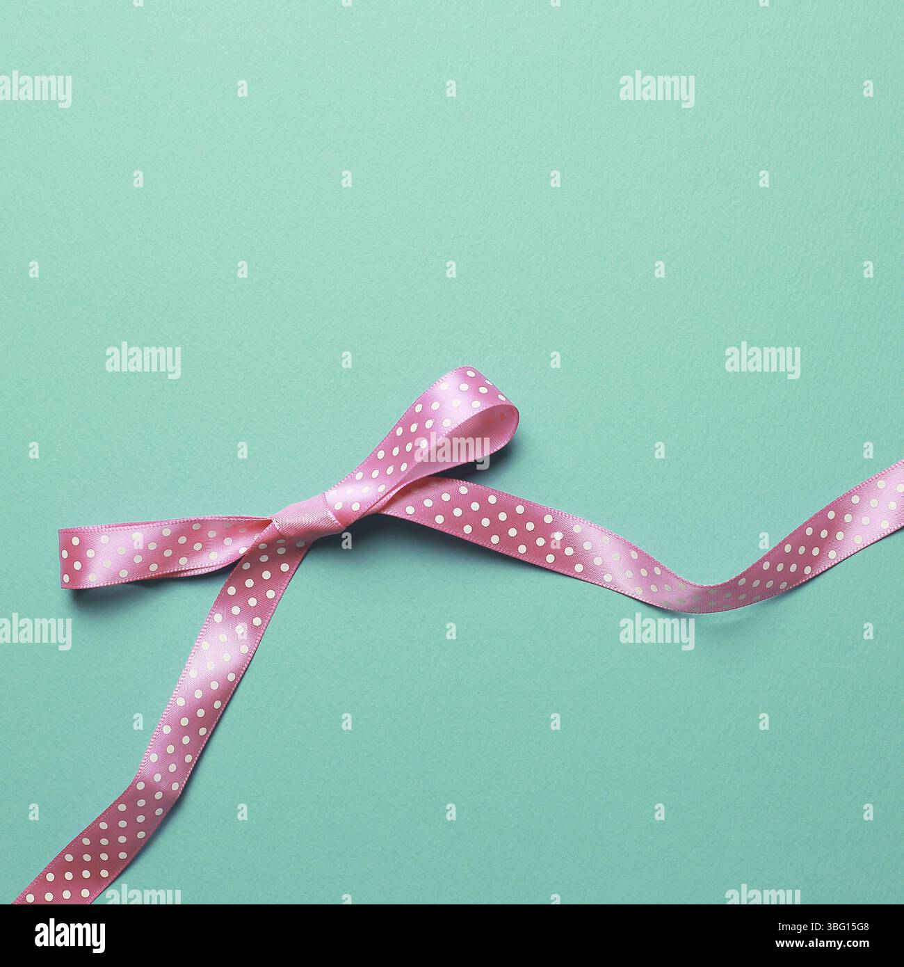 Decorative pink bow ribbon on mint background Stock Photo