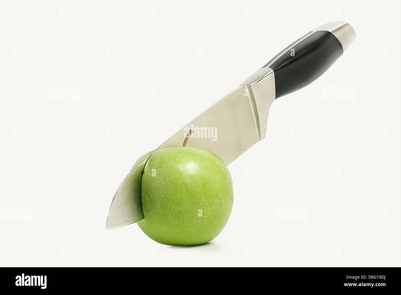 knife cutting green apple in half isolated Stock Photo - Alamy