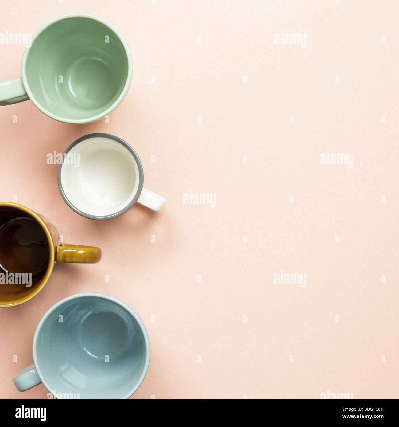Colorful empty mug cups on pink background. top view Stock Photo