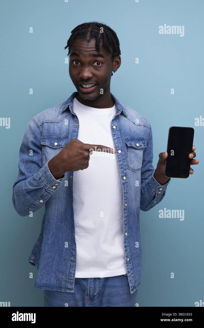 Smiling african man with black dreadlocks using smartphone Stock Photo