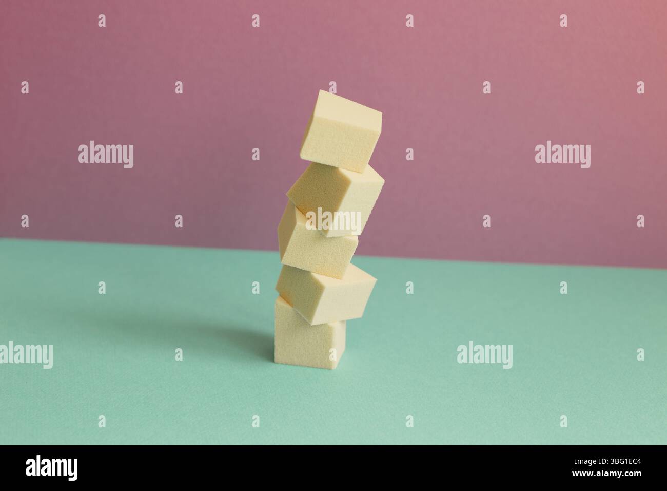 Stack of makeup sponge on mint green table. pink wall background Stock Photo