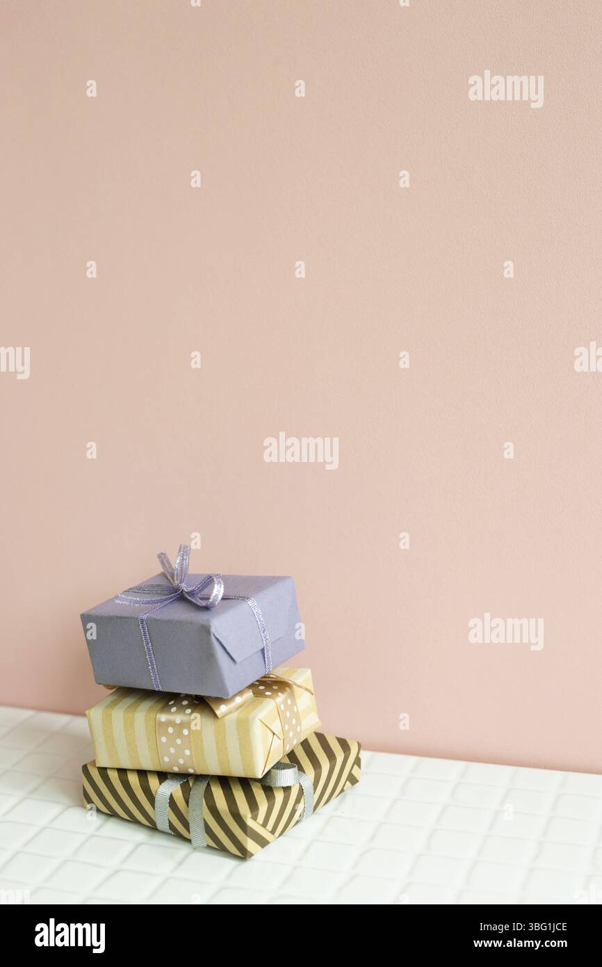 Colorful gift boxes on white table. pink wall background Stock Photo