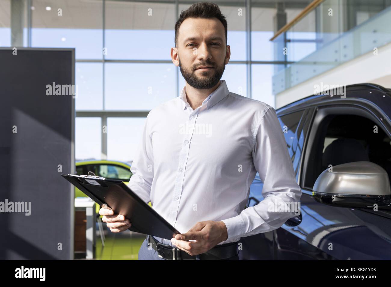 Manager in einem autohaus bereitet papiere fuer den kauf eines neuen autos Stock Photo