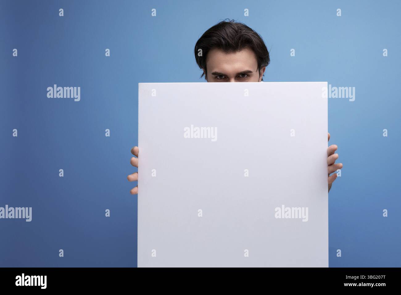 Young brutal brunette guy with poster mockup Stock Photo