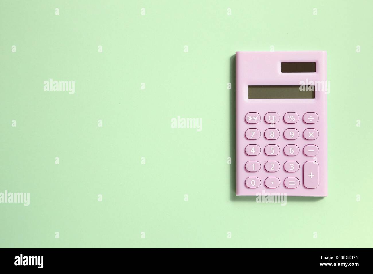 Pink digital calculator on green background Stock Photo