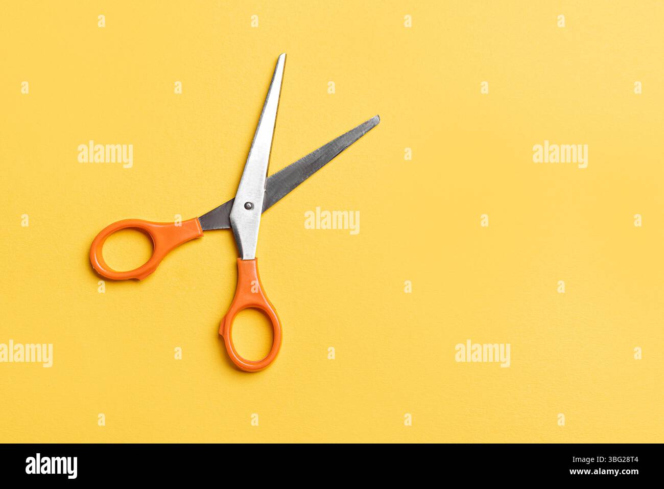 Open scissors on bright yellow background, top view, copy space. Stock Photo
