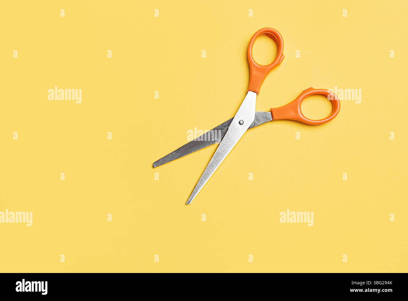 Open scissors on bright yellow background, top view, copy space. Stock Photo