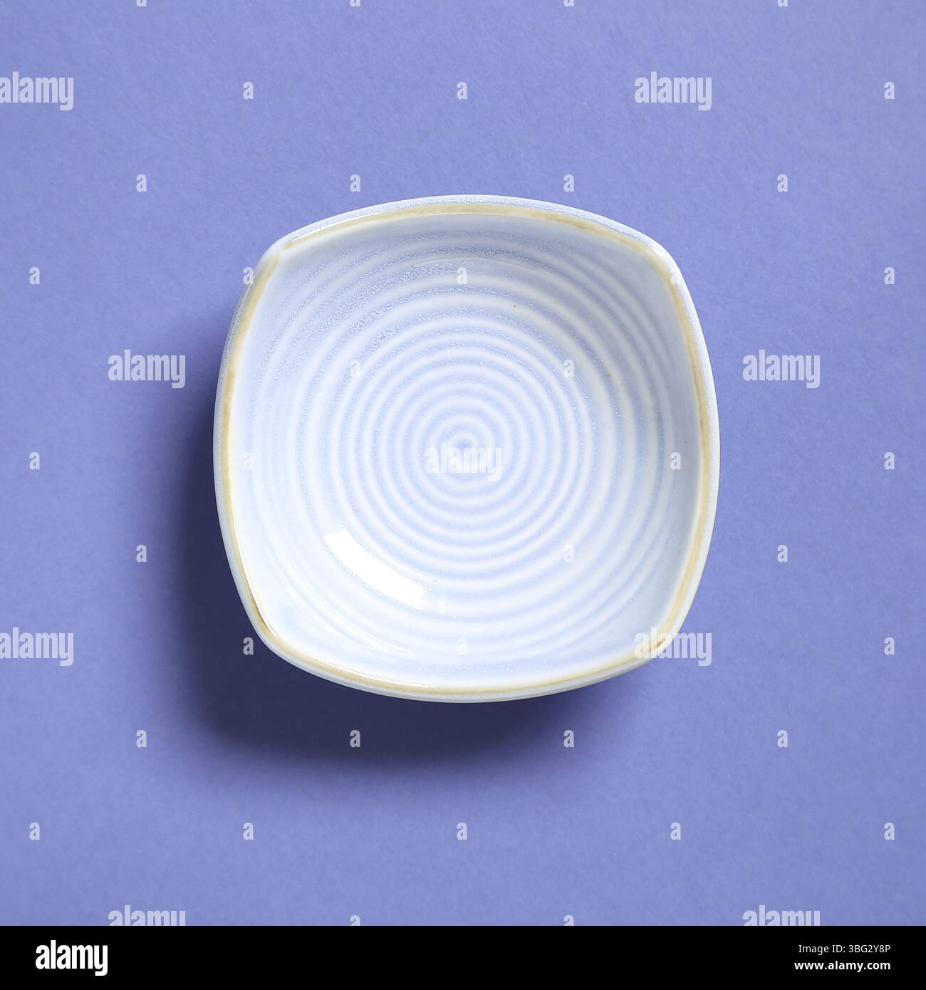 Blue dish isolated on purple background Stock Photo