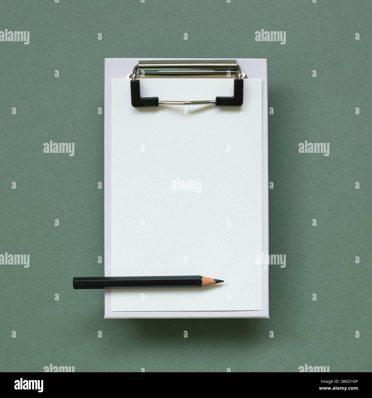 Clipboard and paper sheet on green background. top view, copy space Stock Photo