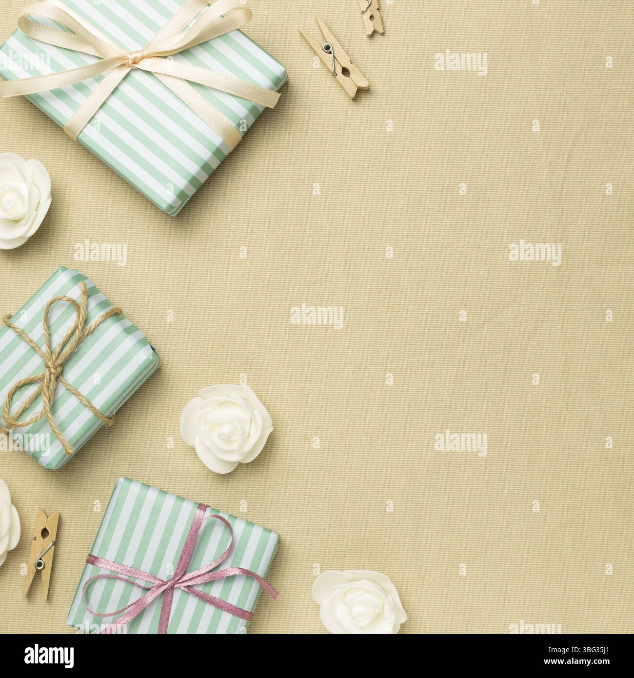 Green gift boxes on beige fabric background. flat lay, top view, copy space Stock Photo