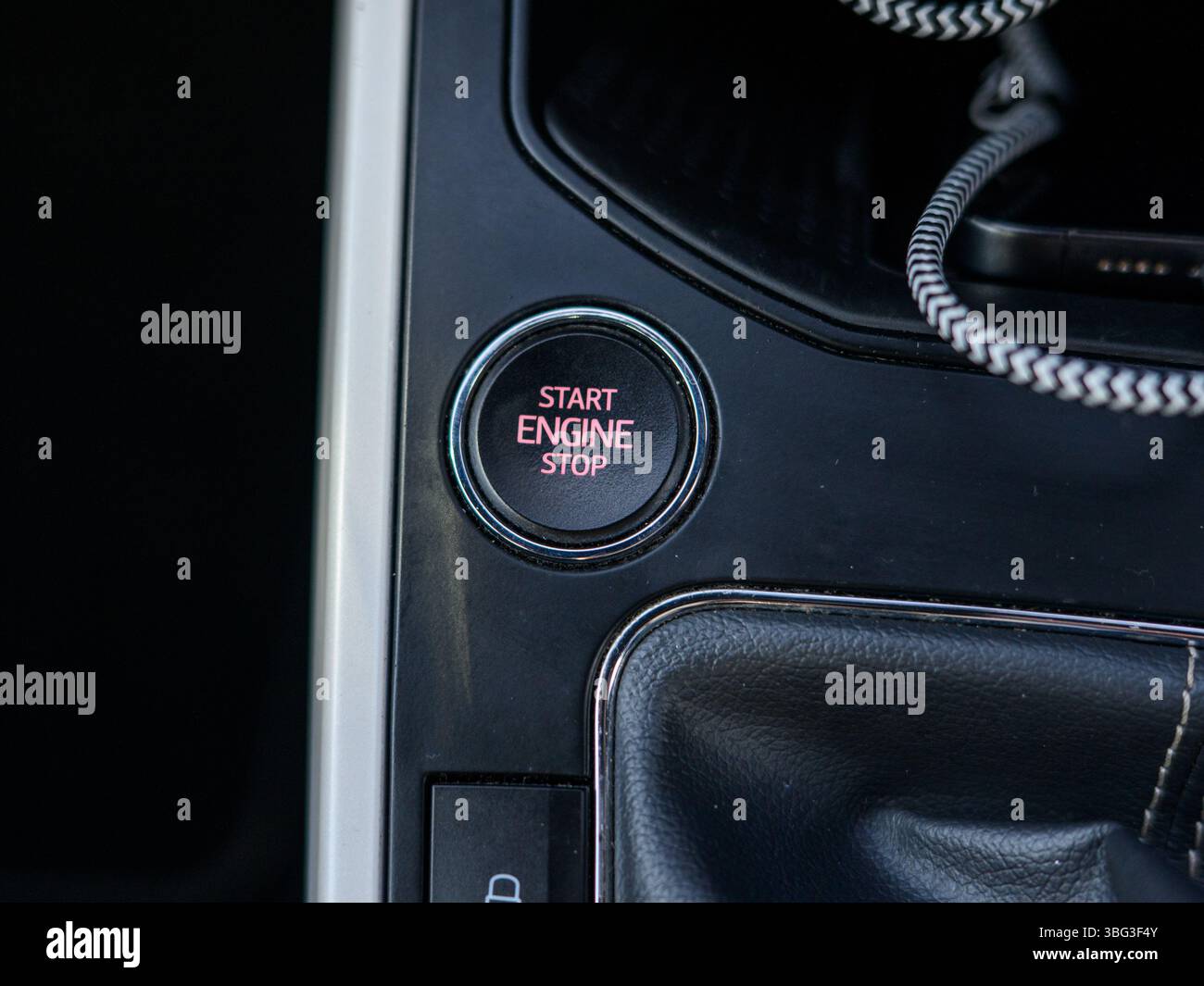 This image highlights a sleek engine start/stop button inside a modern vehicle, typically located on the dashboard, offering keyless ignition function Stock Photo