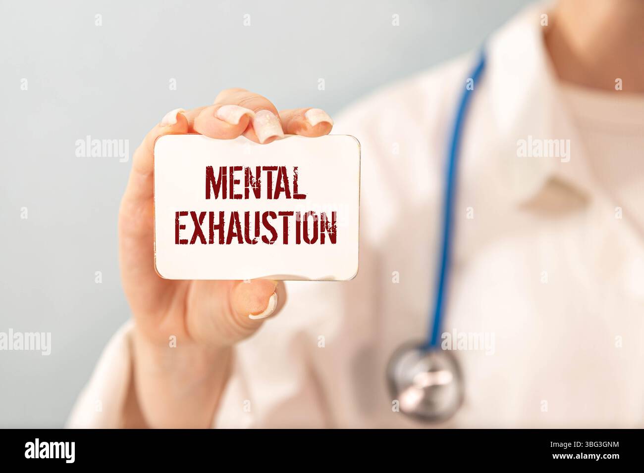 Concept of Mental exhaustion write on sticky notes isolated on Wooden Table. Stock Photo