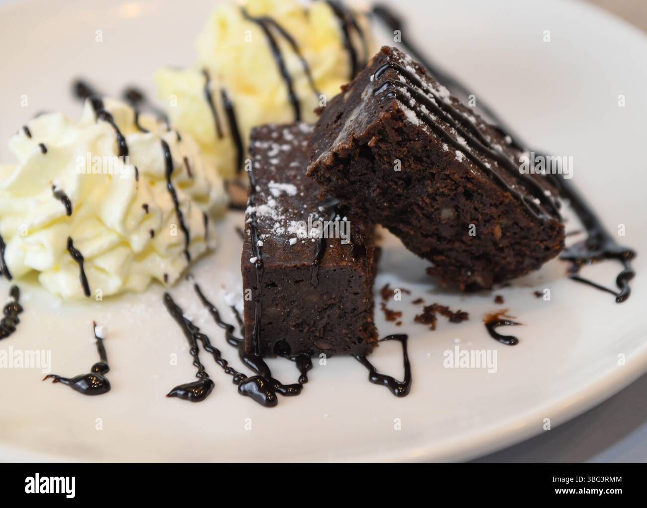 Chocolate brownies with whipped cream and vanilla ice cream on white ...