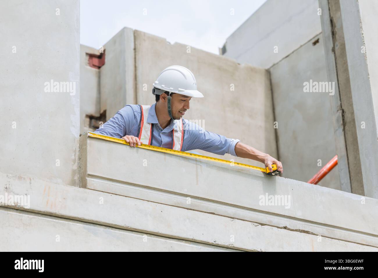 Home builder worker using tape measurement working in house building construction site Stock Photo