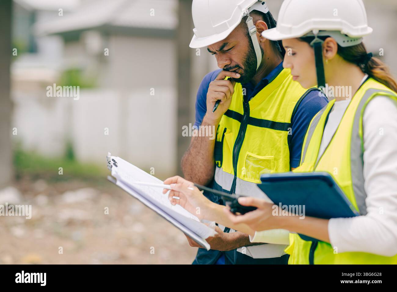 Construction engineer foreman thinking solving problem when talking with site manager about problem Stock Photo