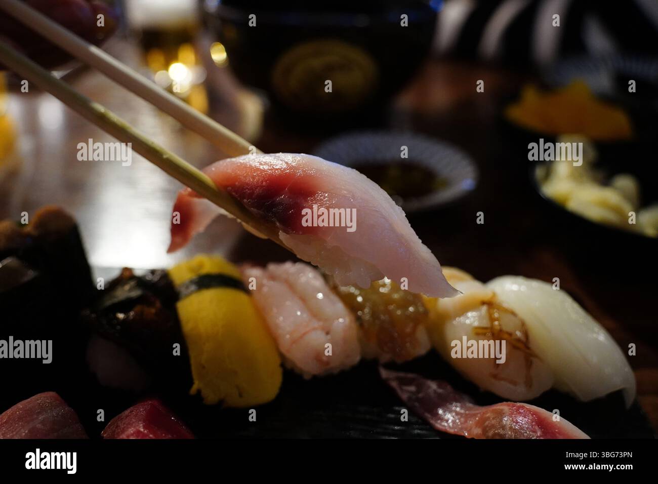 Chopsticks Picking Up Nigiri Sushi – Japanese Cuisine Stock Photo