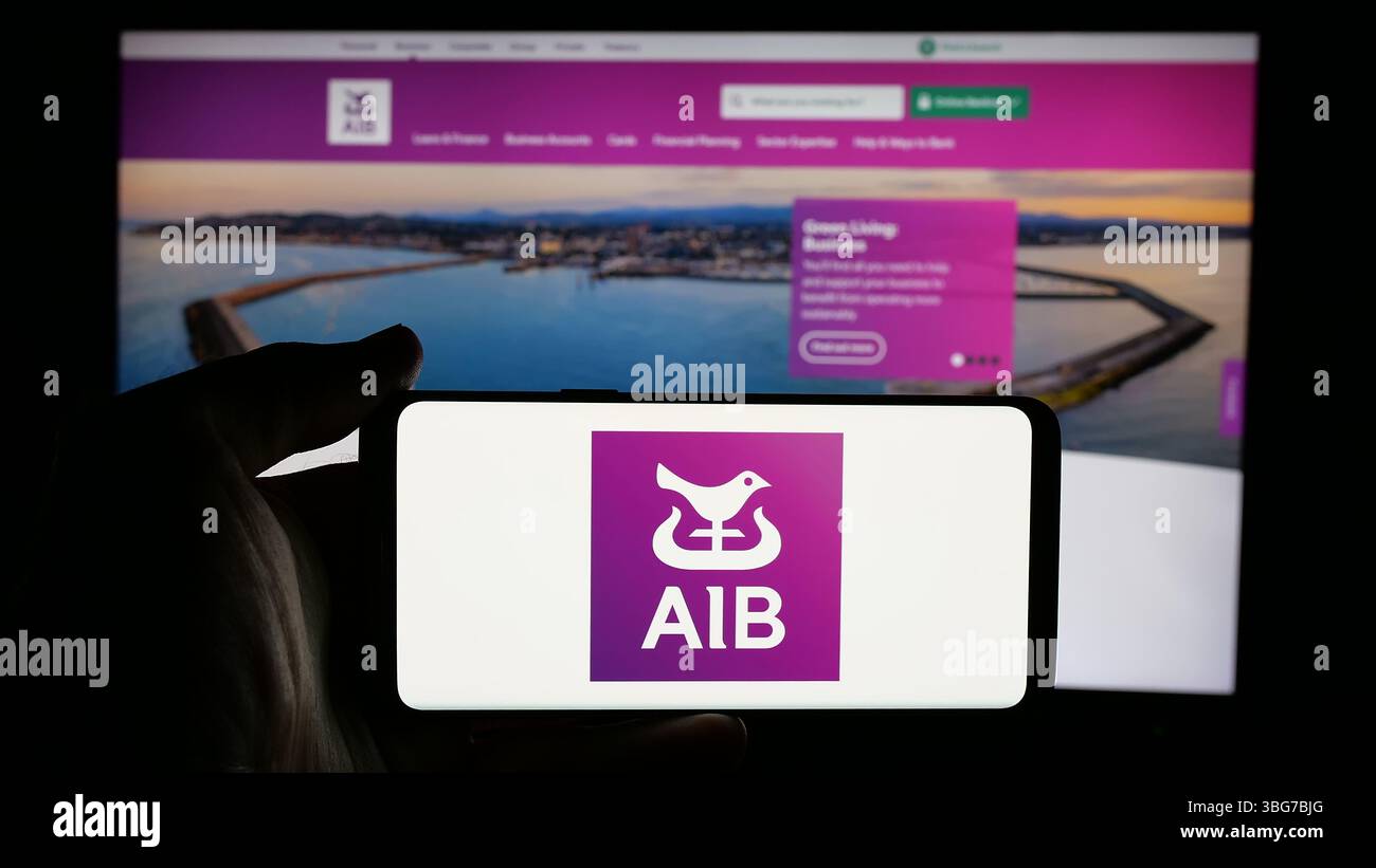 Stuttgart, Germany - 01-28-2025: Person holding cellphone with logo of financial company Allied Irish Banks plc (AIB) on screen Stock Photo