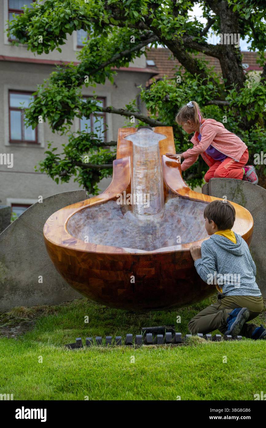 Children playing with wooden water feature in garden park, natural play and outdoor learning concept Stock Photo