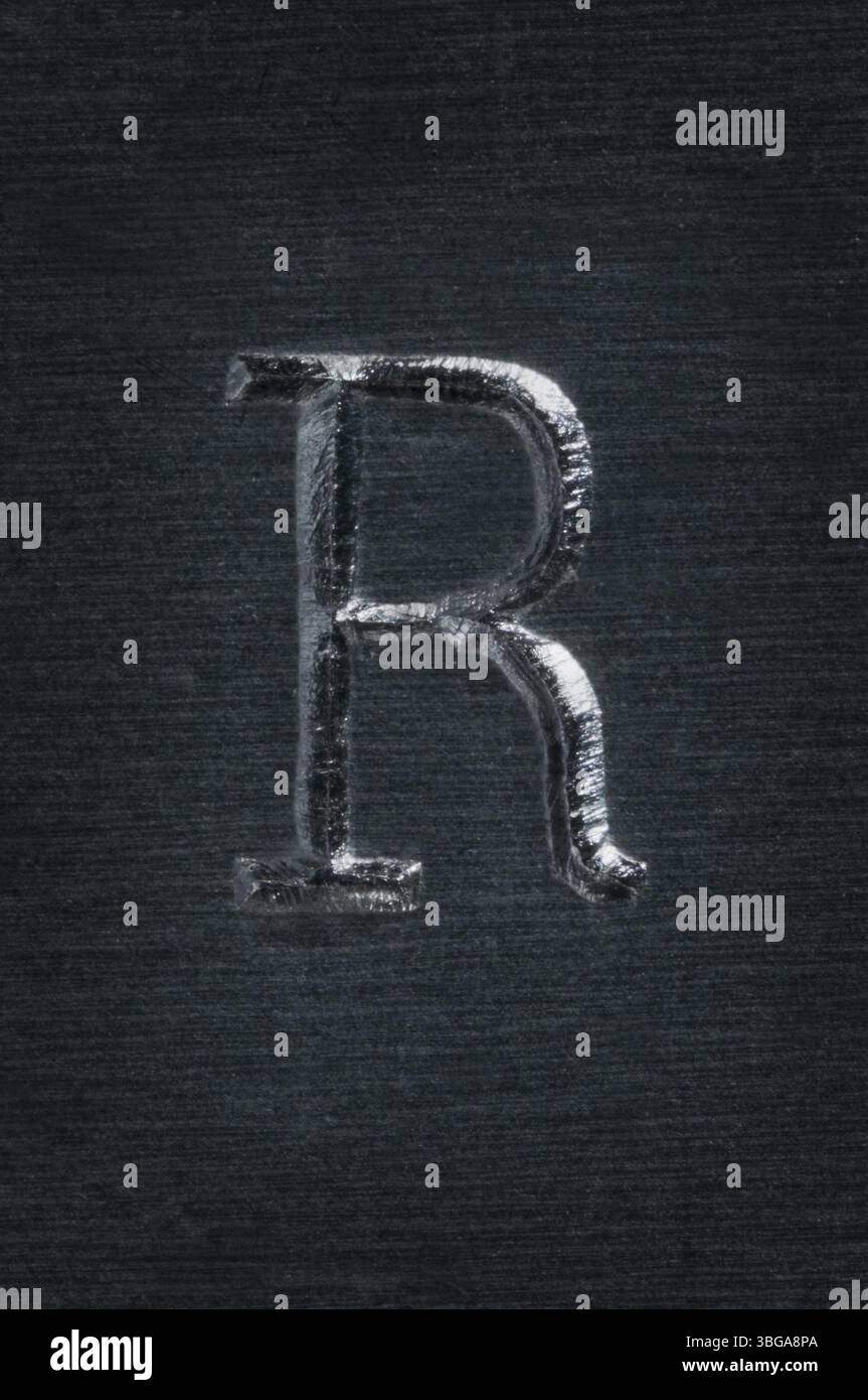 Macro image of the letter R hammered into metal Stock Photo - Alamy