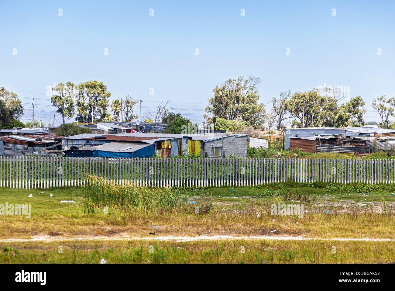 Third world shanty town in Icola Street, Khayelitsha area on the outskirts of Cape Town with houses and shacks made of corrugated iron panels. Stock Photo