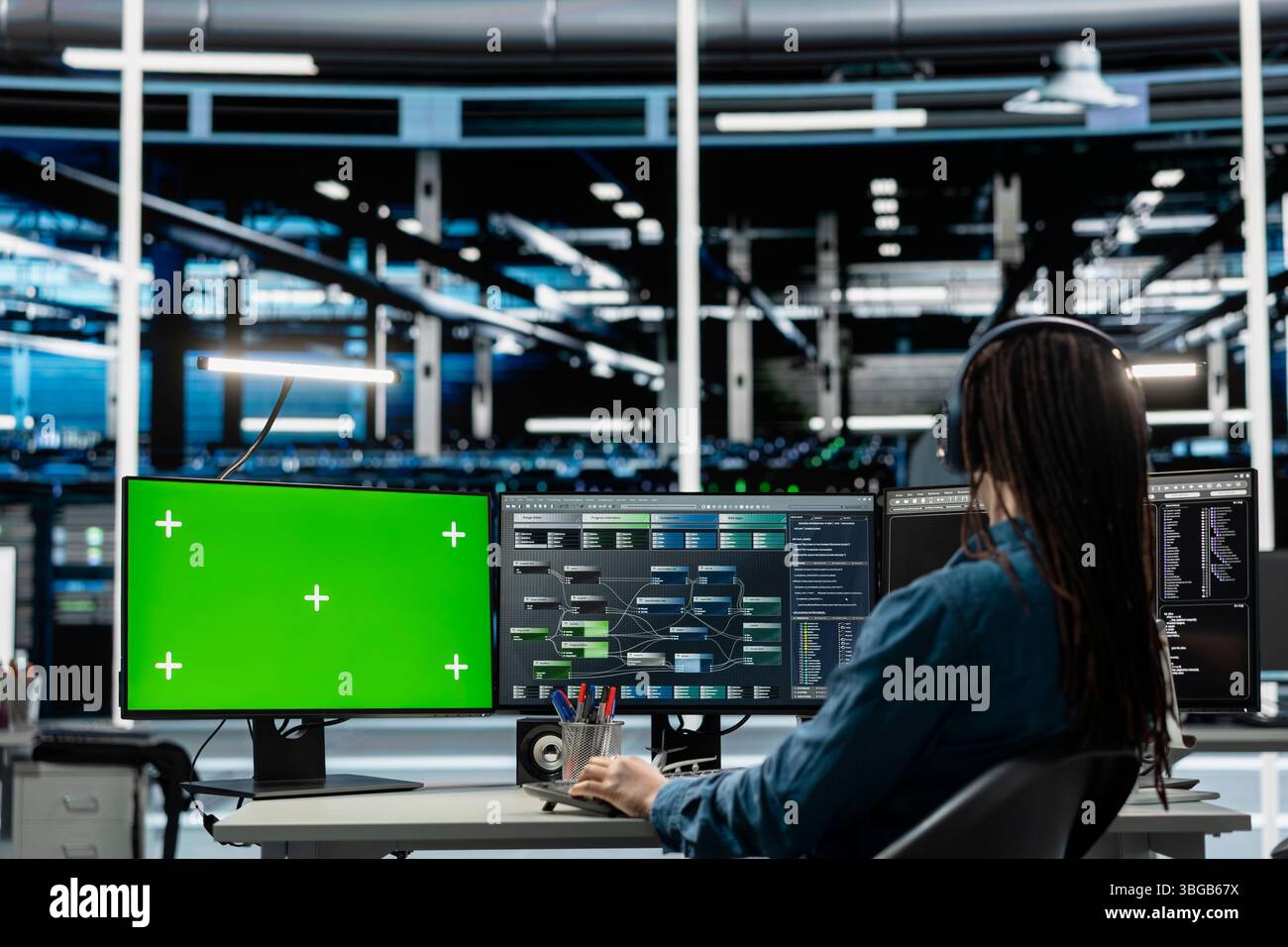 Programmer in data center using isolated screen computer to check equipment performance upgrading infrastructure. IT expert doing maintenance on supercomputers in servers room using chroma key PC Stock Photo