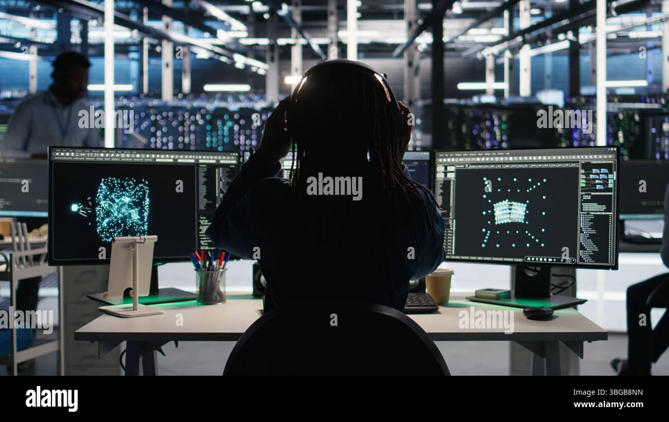 Data center engineer implements AI virtualization frameworks to optimize server clusters. Server hub IT professional doing artificial intelligence predictive analysis, camera A Stock Photo