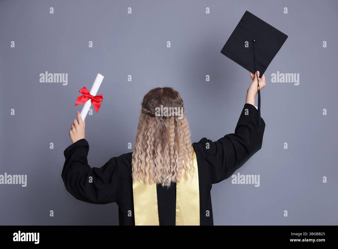 Student with diploma and mortarboard after graduation on grey ...