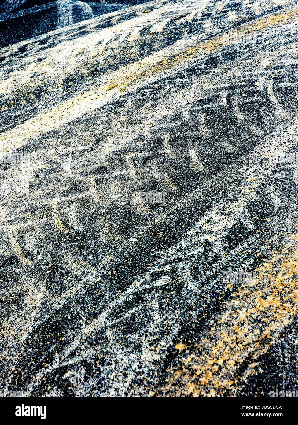Tractor tyre tracks and crushed spilled grain on road surface resulting from wet conditions on farmyard gravel surface - central France. Stock Photo