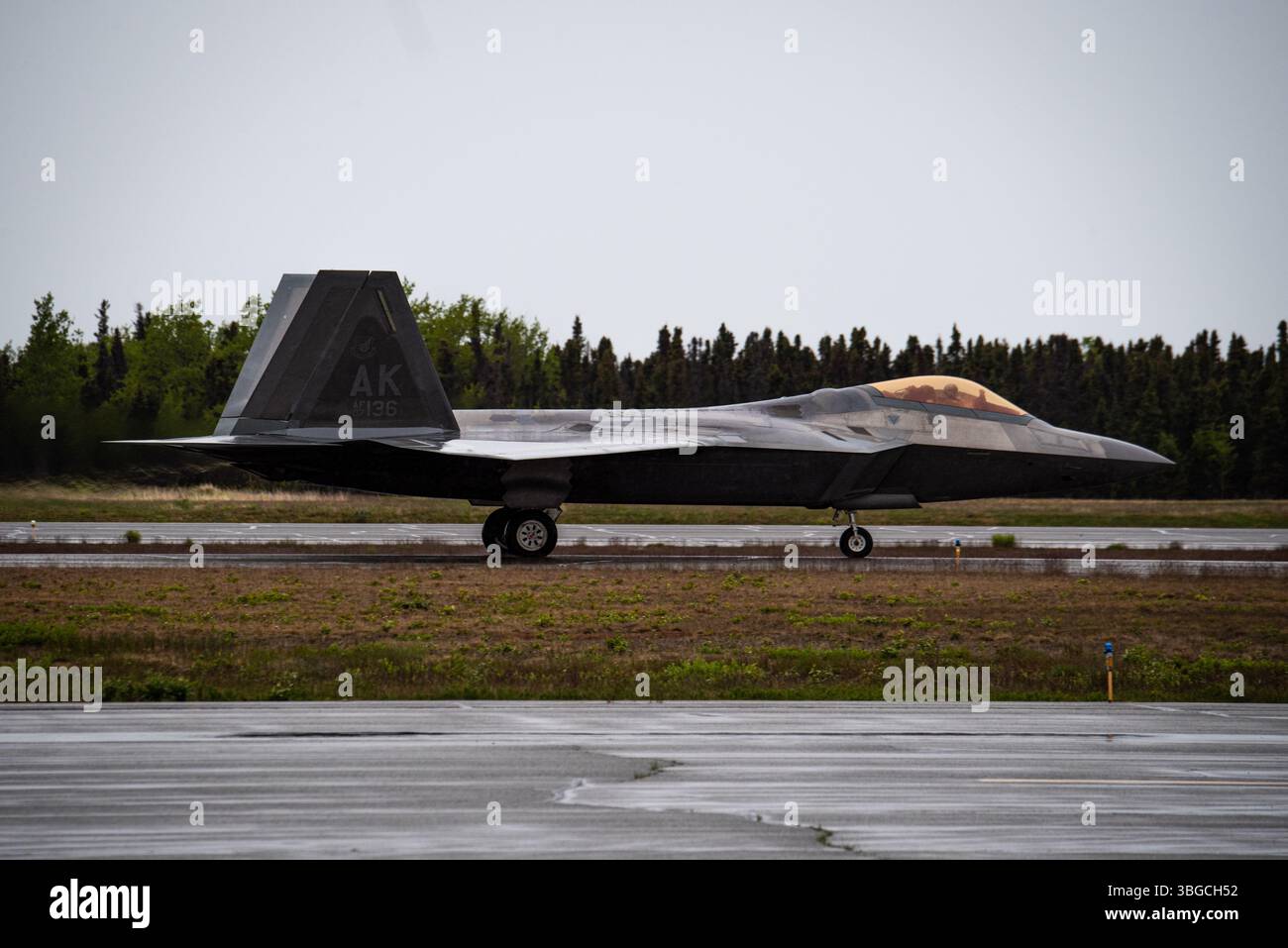 A U.S. Air Force F-22 Raptor assigned to the 3rd Wing taxis for takeoff on a flightline during Exercise Tropic Tundra at a remote location in Alaska, June 3. The F-22 is an American twin-engine, all-weather, supersonic stealth fighter aircraft and provides power projection across the Indo-Pacific region. Airmen assigned to the 673d Air Base Wing and 3rd Wing  came together to form the 3rd Air Expeditionary Wing during the exercise, testing and training their ability to receive and launch F-22 Raptor aircraft in austere locations and execute Agile Combat Employment techniques in preparations fo Stock Photo