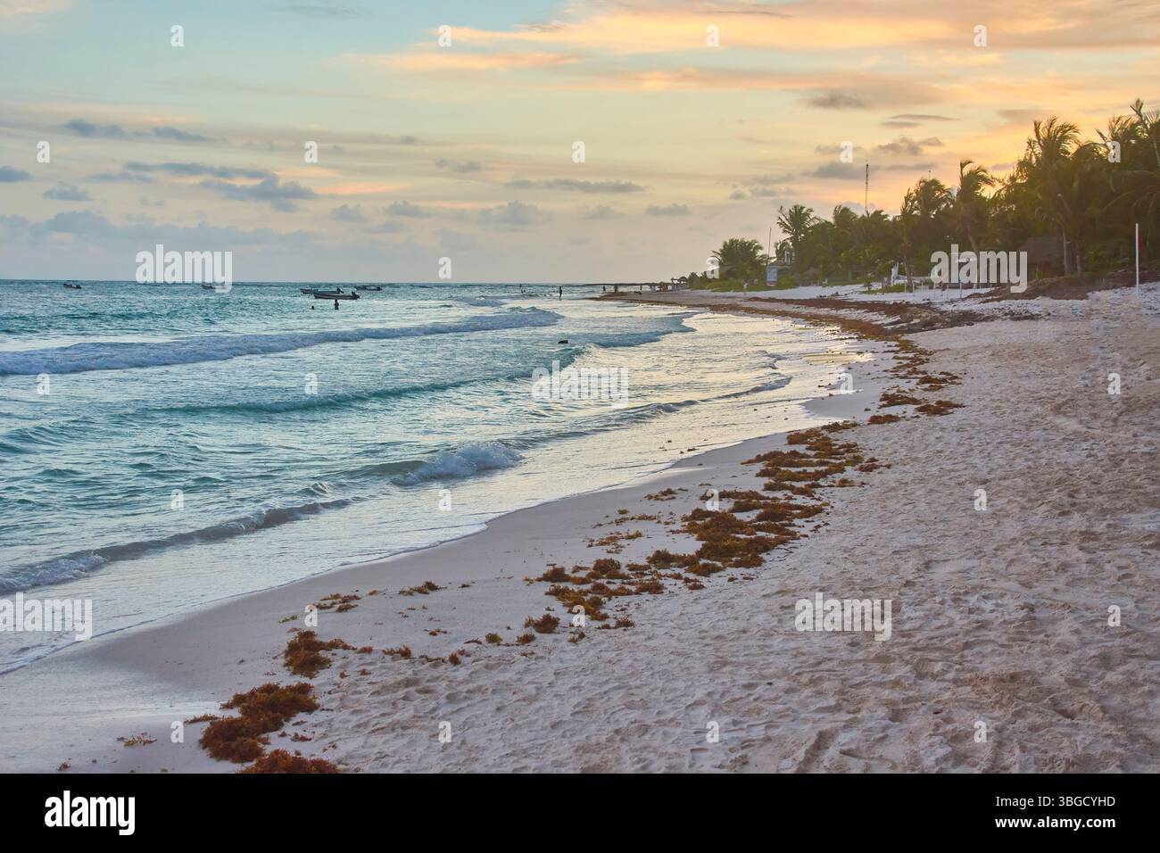 Stunning sunset over the caribbean sea with turquoise waters lapping on ...