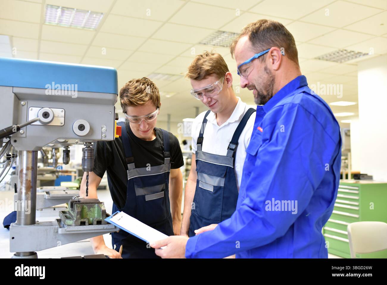 trainer and apprentice in technical vocational training at a drilling machine Stock Photo
