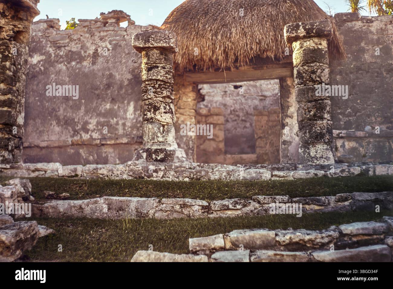 Stone columns supporting a thatched roof at mayan ruins in tulum, mexico Stock Photo