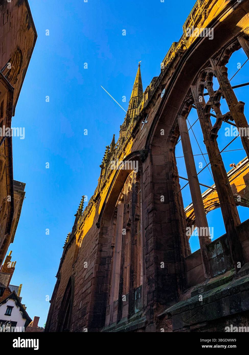 A view of the old Coventry Cathedral partially destroyed during world war 2, against a clear blue summer sky. - Smartphone Captured Stock Image