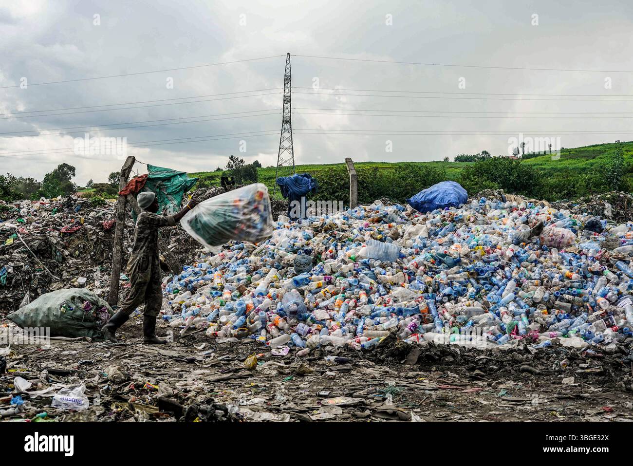An informal waste worker empties bags of plastic waste at a yard in ...