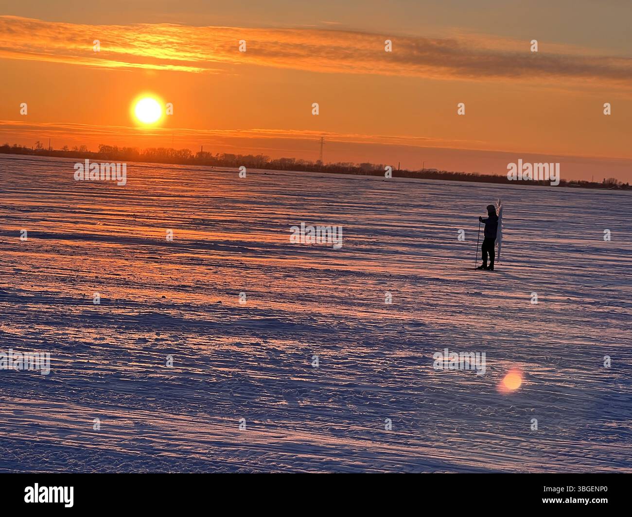 Breathtaking winter sunset over snowy landscape. Mystical skier with angel wings in distance creates surreal, dreamy scene. Ideal for travel, fantasy, Stock Photo