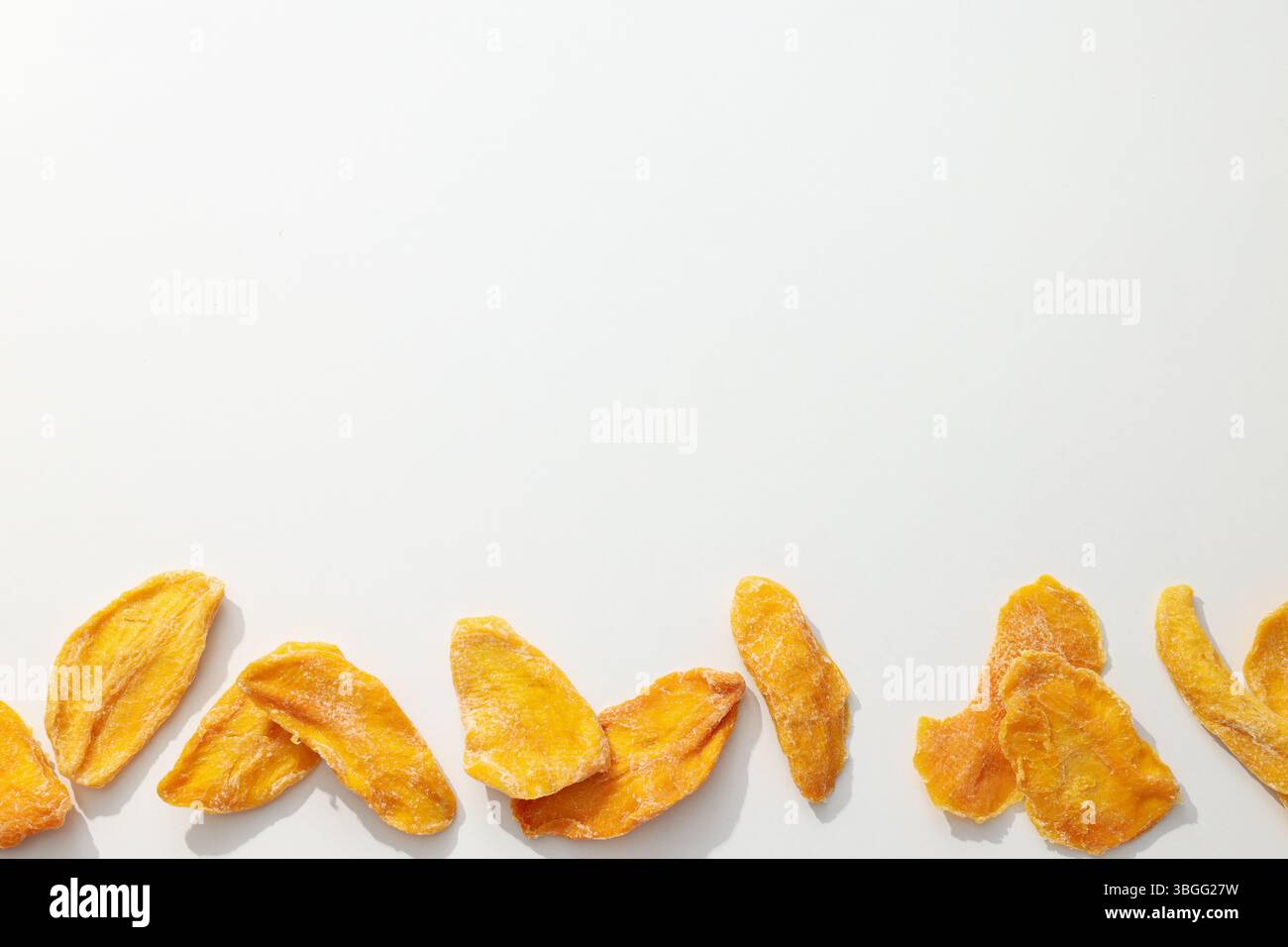 Dried mango chips on a white background Stock Photo