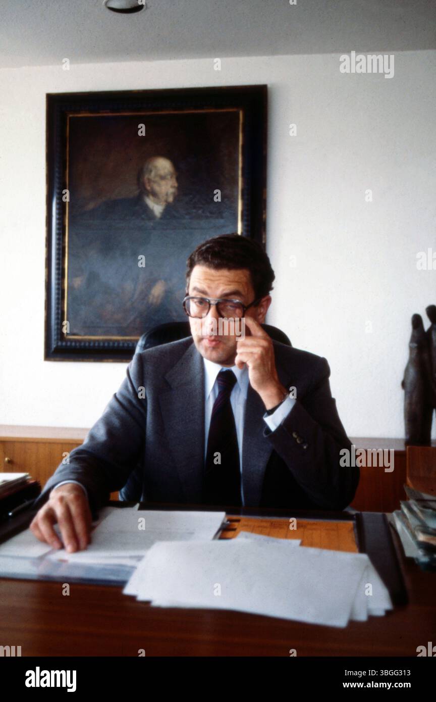 Gerhart Baum, Bundesinnenminister der FDP, an seinem Schreibtisch im Ministerbüro. Der Politiker sitzt konzentriert vor Akten und Unterlagen, hinter ihm ein Gemälde, Otto von Bismarck zeigend, sowie moderne Skulpturendekoration. Stock Photo
