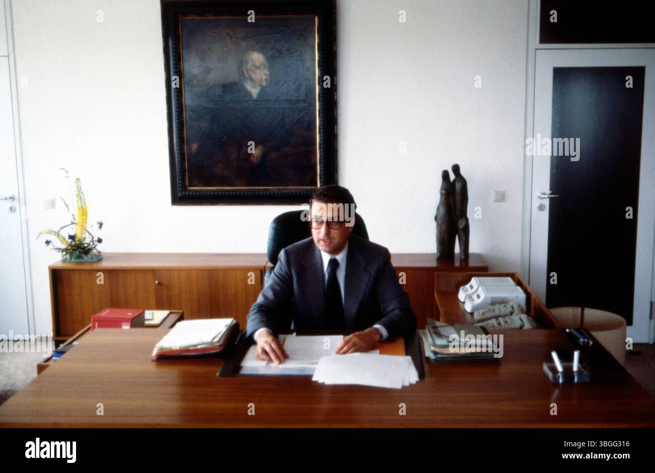 Gerhart Baum, Bundesinnenminister der FDP, an seinem Schreibtisch im Ministerbüro. Der Politiker sitzt konzentriert vor Akten und Unterlagen, hinter ihm ein Gemälde, Otto von Bismarck zeigend, sowie moderne Skulpturendekoration. Stock Photo