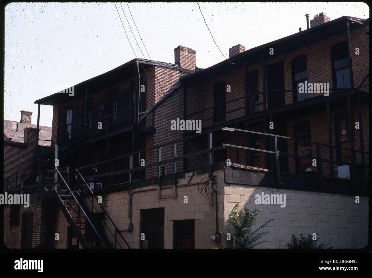 A rear view of an unidentified three-story brick building with metal ...
